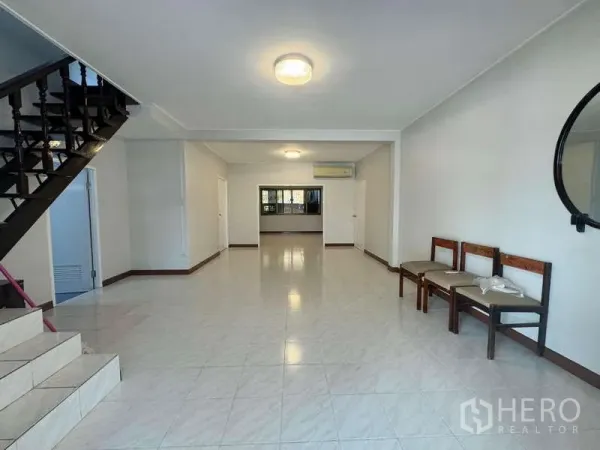 Detached House for rent in Wang Thonglang, Bangkok - Spacious open-plan living room with tiled floors, staircase, windows and air conditioning.