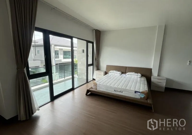 独立式住宅 出租在Bang Phli, Samut Prakan - 卧室通过大推拉门连接阳台，木地板温馨。