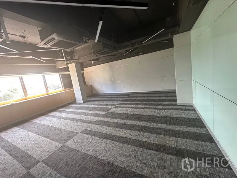 Office Space for rent in Khlong Toei, Bangkok - Bright workspace with full-length windows, white wall panels and modern ceiling lights.