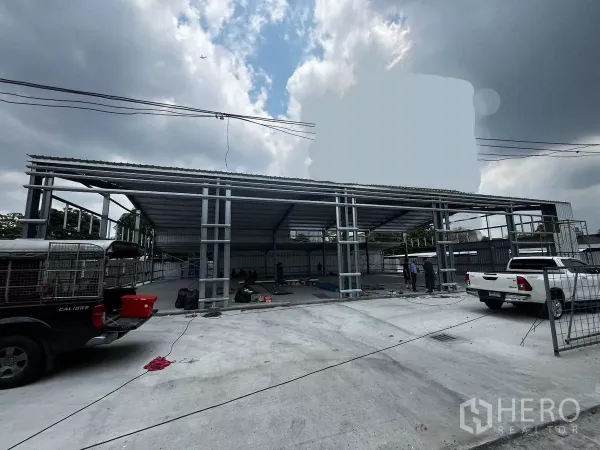 货栈 出租在Lak Si, Bangkok - 仓库正面外观（施工中），配有宽阔混凝土场地与皮卡车进出。