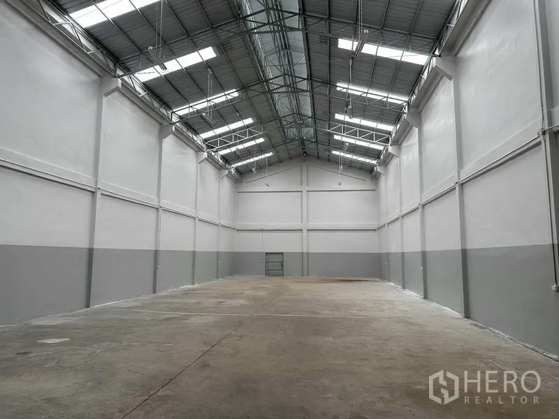 โรงงาน ให้เช่าในNonthaburi - ฮอลล์คลังสินค้าเพดานสูง โครงหลังคาเหล็ก มีสกายไลท์และพื้นคอนกรีตเรียบ