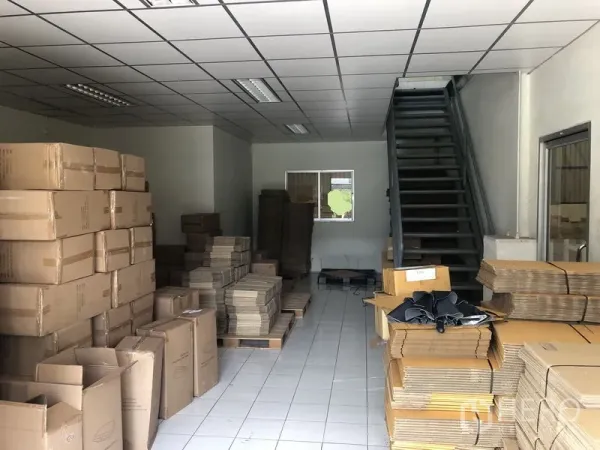 Factory for rent in Khlong Luang, Pathum Thani - Ground-floor office and packing area with tiled floor, fluorescent lighting and a staircase to the upper level.