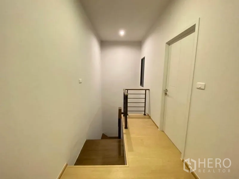 ทาวน์เฮาส์ ให้เช่าในPrawet, Bangkok - โถงทางเดินชั้นบน พื้นบันไดไม้ ราวจับ และไฟดาวน์ไลต์