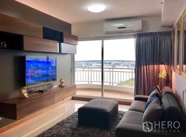 คอนโด ให้เช่าในBangkok - พื้นที่นั่งเล่นหันสู่ประตูกระจกบานเลื่อน ออกสู่ระเบียงชมวิวแม่น้ำ พร้อมทีวีติดผนังและชั้นบิลท์อิน