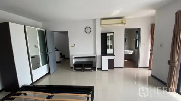 联排别墅 出租在Bang Na, Bangkok - 宽敞卧室，配衣柜、空调、书桌并可通往套卫。