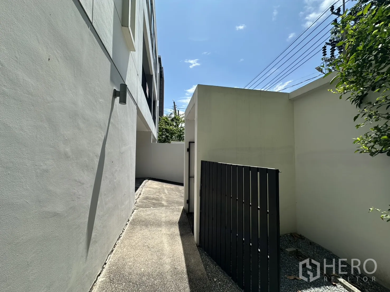 Home Office for rent in Phra Khanong, Bangkok - Side walkway along the house leading to the rear yard behind a gate.