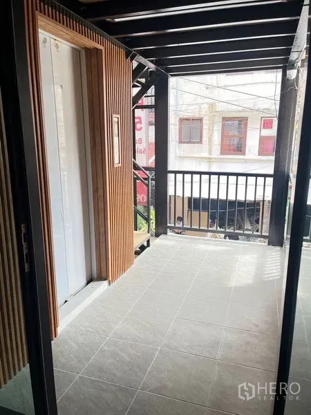 พื้นที่ขายปลีก ให้เช่า - ระเบียงหน้าอาคารแบบมีหลังคา ราวเหล็ก และบันไดนอกอาคาร มองเห็นถนน