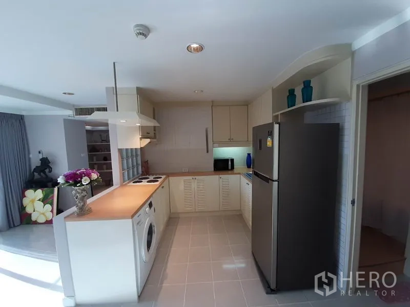 公寓 出租或出售在Watthana, Bangkok - 开放式厨房面向起居区，台面宽敞，储物空间充足。