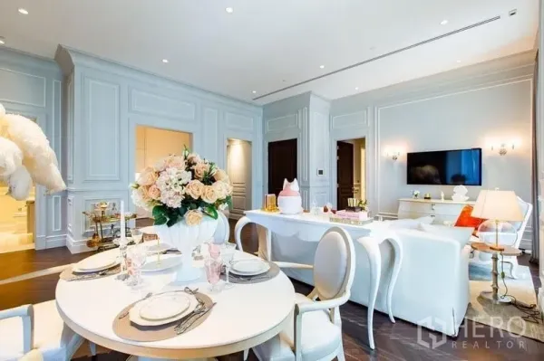Condominium for sale in Pathum Wan, Bangkok - Chic dining corner with round table and floral centerpiece adjoining the living area.