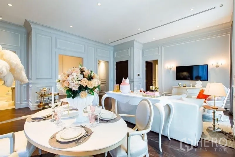 Condominium for sale in Pathum Wan, Bangkok - Chic dining corner with round table and floral centerpiece adjoining the living area.