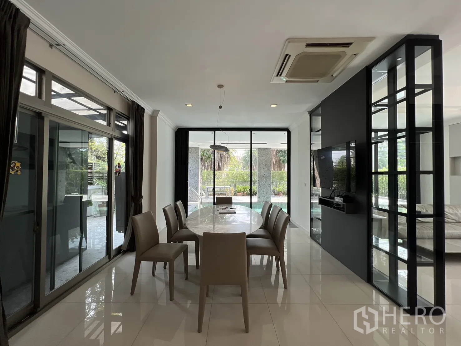 独栋房屋 for rent in Prawet, Bangkok - 餐厅配嵌入式电视墙与推拉门通向泳池露台。