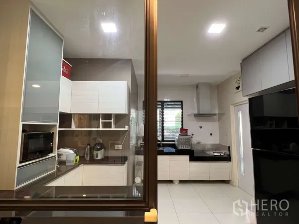 Detached House for rent in Prawet, Bangkok - Enclosed kitchen featuring ample cabinetry, countertops, window and range hood.