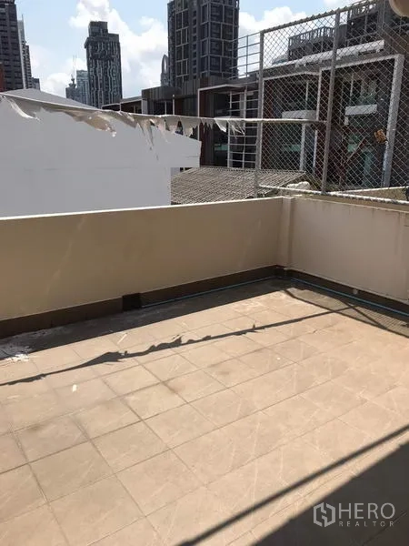Townhouse for rent in Khlong Toei, Bangkok - Rooftop terrace with tiled floor and city view in Khlong Toei.