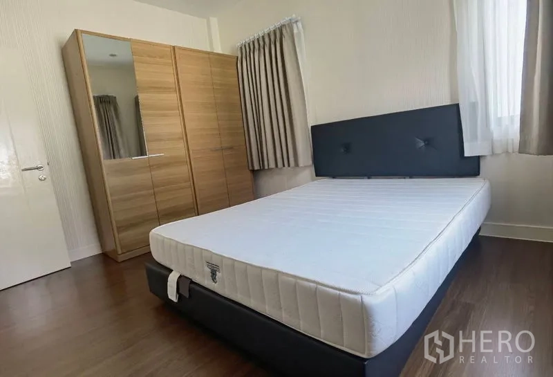บ้าน ให้เช่าในBang Kapi, Bangkok - ห้องนอนรอง เตียงบุนวม ตู้เสื้อผ้า และพื้นไม้โทนอุ่น