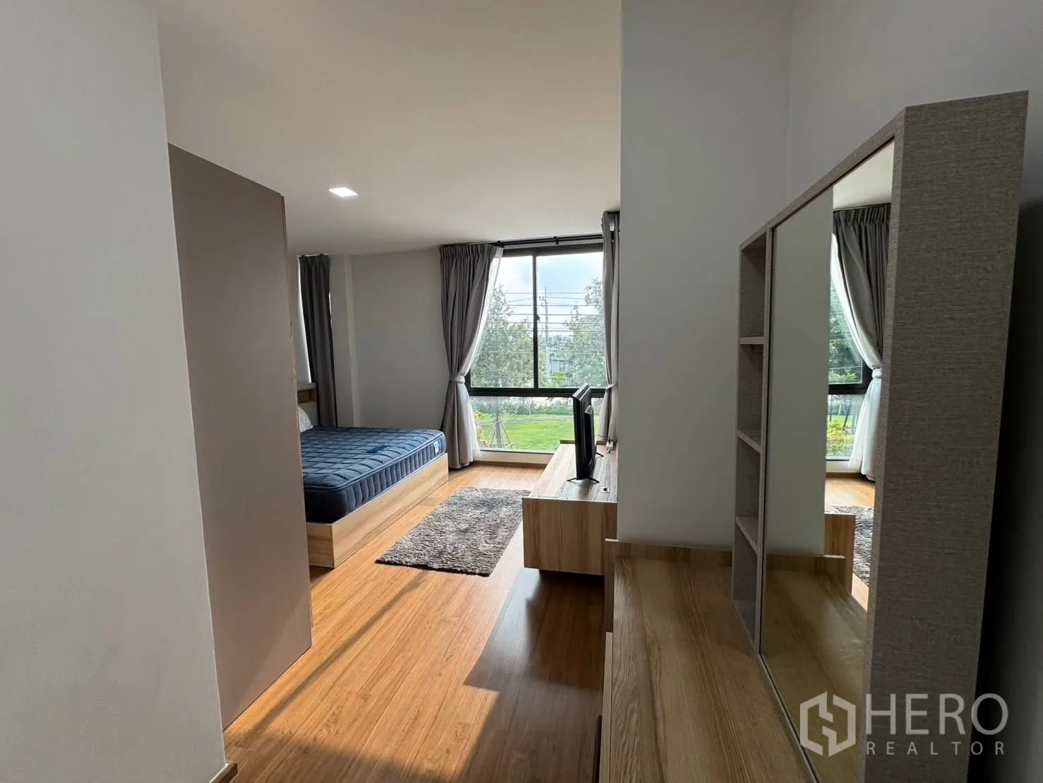 Townhouse for rent in Bang Phli, Samut Prakan - View from the dressing area into the primary bedroom with big windows and TV.