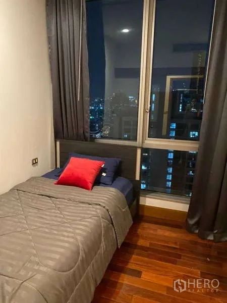 คอนโด ขายในSathon, Bangkok - ห้องนอนรอง เตียงเดี่ยว หน้าต่างเต็มบานมองเห็นวิวเมืองยามค่ำ.