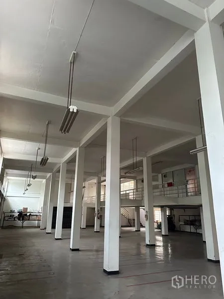 อาคารพาณิชย์ ให้เช่าในKhlong Toei, Bangkok - ฮอลล์เปิดโล่ง เสาสีขาว ไฟแขวน และชั้นลอยสำนักงานภายในอาคารพาณิชย์