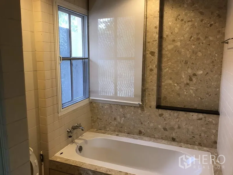 บ้าน ขายในWang Thonglang, Bangkok - ห้องน้ำพร้อมอ่างอาบน้ำ ผนังลายเทอร์ราซโซ หน้าต่าง และมู่ลี่.