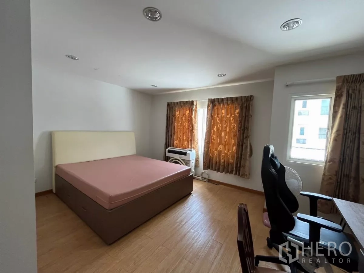 Townhouse for rent in Bang Kho Laem, Bangkok - Bright bedroom with large bed, multiple windows, and work desk.