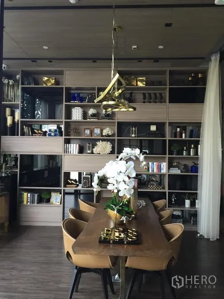 Condominium for rent in Watthana, Bangkok - Residents’ lounge and library with long table, designer pendant light and built‑in shelves.