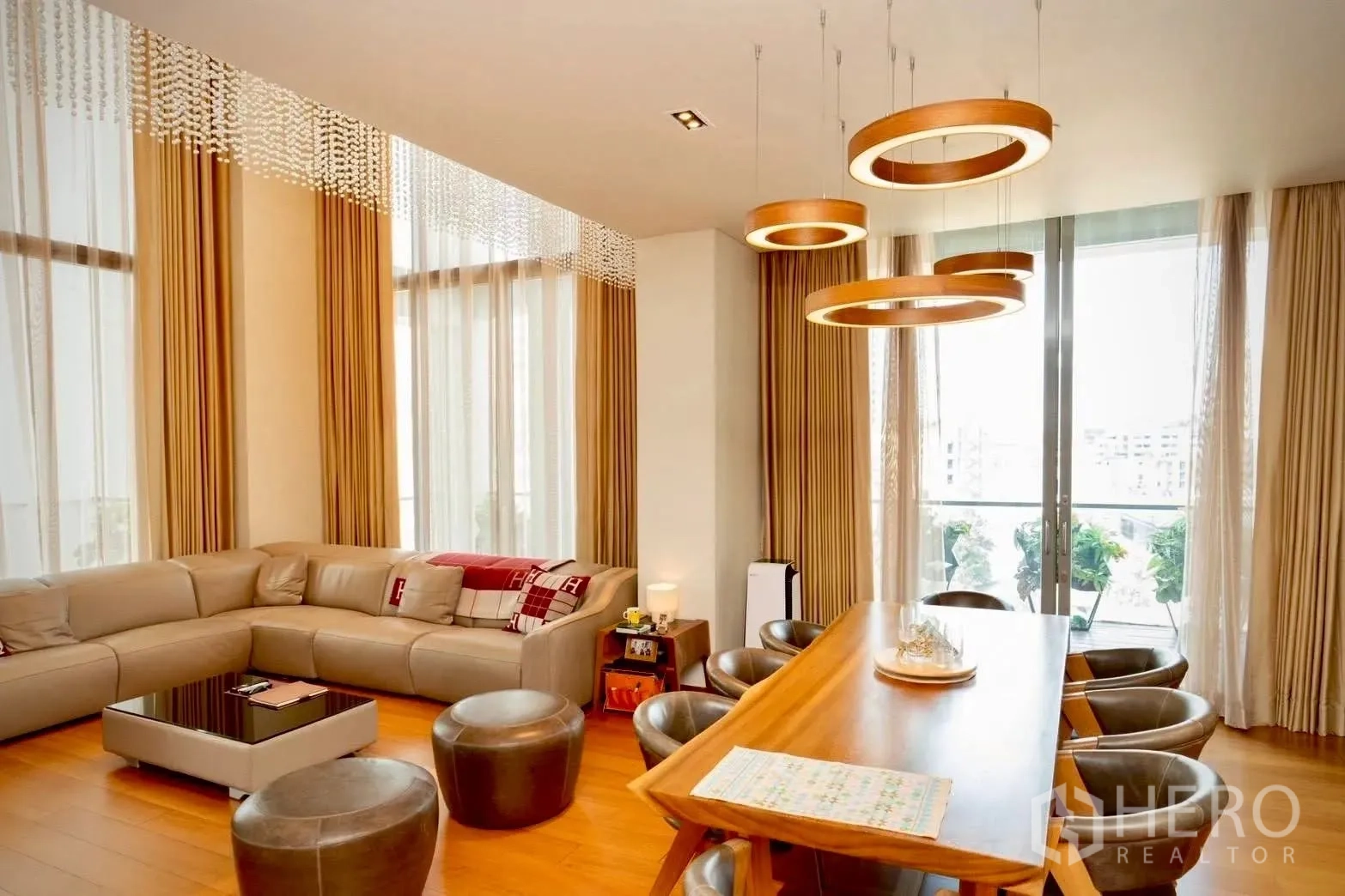 Condominium for sale in Sathon, Bangkok - Open-plan living and dining with ring pendant lights and balcony doors.