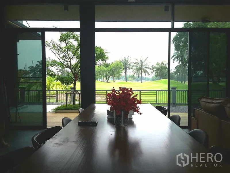 บ้าน ให้เช่าหรือขายในLam Luk Ka, Pathum Thani - พื้นที่รับประทานอาหาร โต๊ะไม้ยาว กระจกเต็มบานมองสู่สวนและแฟร์เวย์