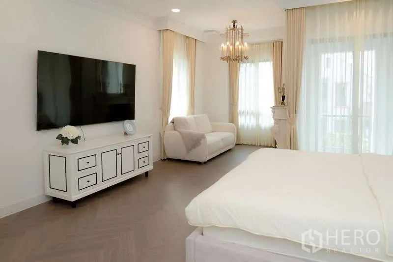 บ้าน ให้เช่าหรือขายในSaphan Sung, Bangkok - อีกมุมของห้องนอนมาสเตอร์ มีทีวีติดผนัง โซฟา และผ้าม่านสูงจรดเพดาน