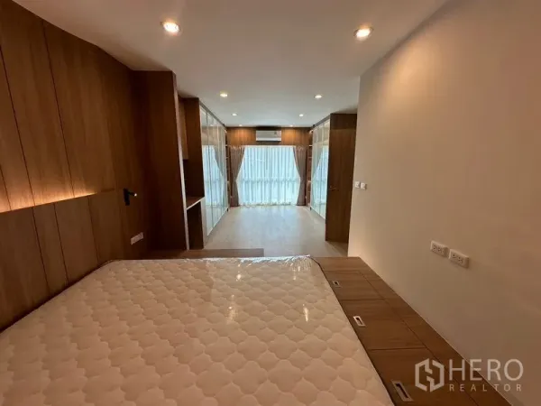 Home Office for rent in Khlong Toei, Bangkok - View across the master suite showing built-in wardrobes, a compact study nook and full curtains.