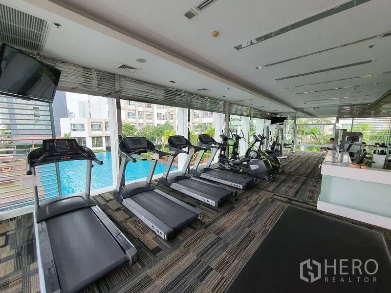 คอนโด ขาย - ห้องฟิตเนสคอนโดมีลู่วิ่งและเครื่องคาร์ดิโอ มองเห็นสระว่ายน้ำกลางแจ้ง