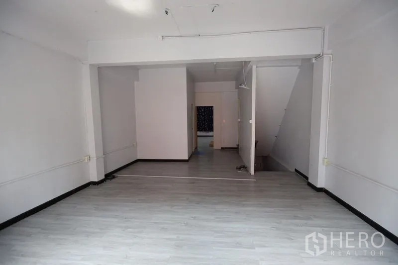 店屋 出租或出售在Watthana, Bangkok - 一层商业空间开阔，灰色地板，隔断及楼梯通向二层
