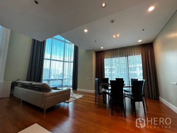 คอนโด ให้เช่าในKhlong Toei, Bangkok - ห้องนั่งเล่นและทานข้าวแบบโอเพนแปลน กระจกสูงจรดเพดาน พื้นไม้ และวิวเมือง