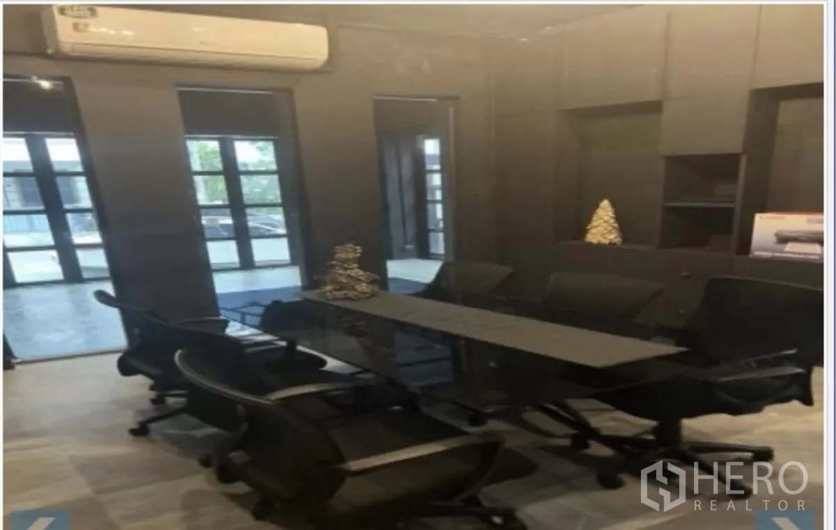 Home Office for rent in Wang Thonglang, Bangkok - Meeting room with a long conference table, office chairs, and glass doors.