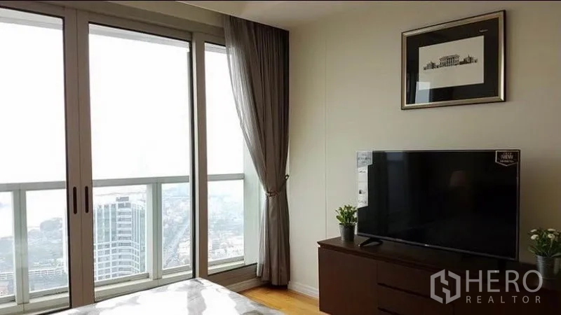 คอนโด ให้เช่าในKhlong San, Bangkok - มุมห้องนอนมีตู้วางทีวี และประตูกระจกบานเลื่อนสูงจรดเพดานมองเห็นสกายไลน์