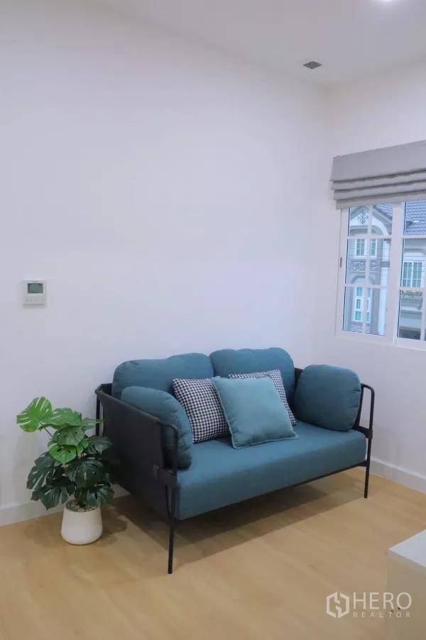 Detached House for rent in Bang Phli, Samut Prakan - Upstairs family lounge with teal sofa, indoor plant and window.