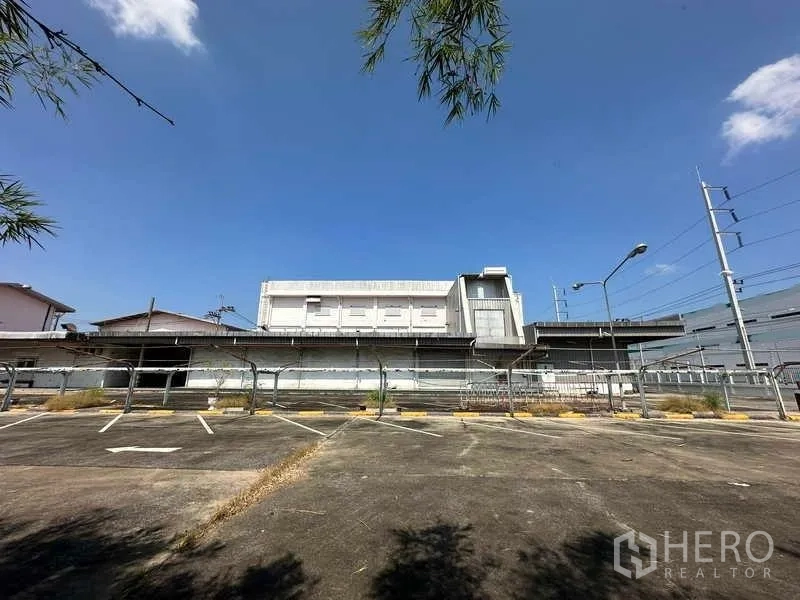 โรงงาน ให้เช่าหรือขายในThanyaburi, Pathum Thani - มุมมองด้านหลังโรงงาน มีท่าขนถ่ายสินค้า รั้ว และที่จอดรถตีเส้น