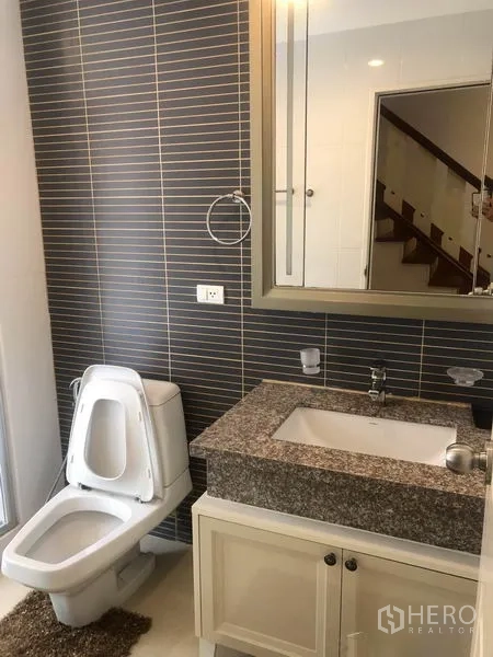 独立式住宅 出租或出售在Pak Kret, Nonthaburi - 浴室配花岗岩台面洗手台、镜柜与条纹墙砖