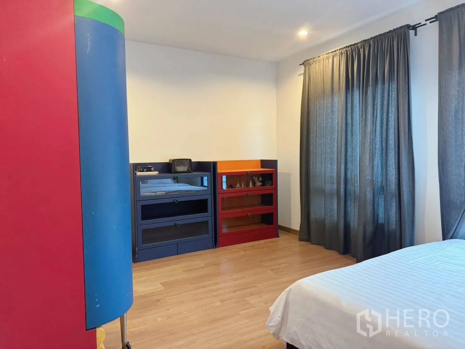 Detached House for rent or sale in Suan Luang, Bangkok - Bedroom with colorful storage units, bed and dark curtains.