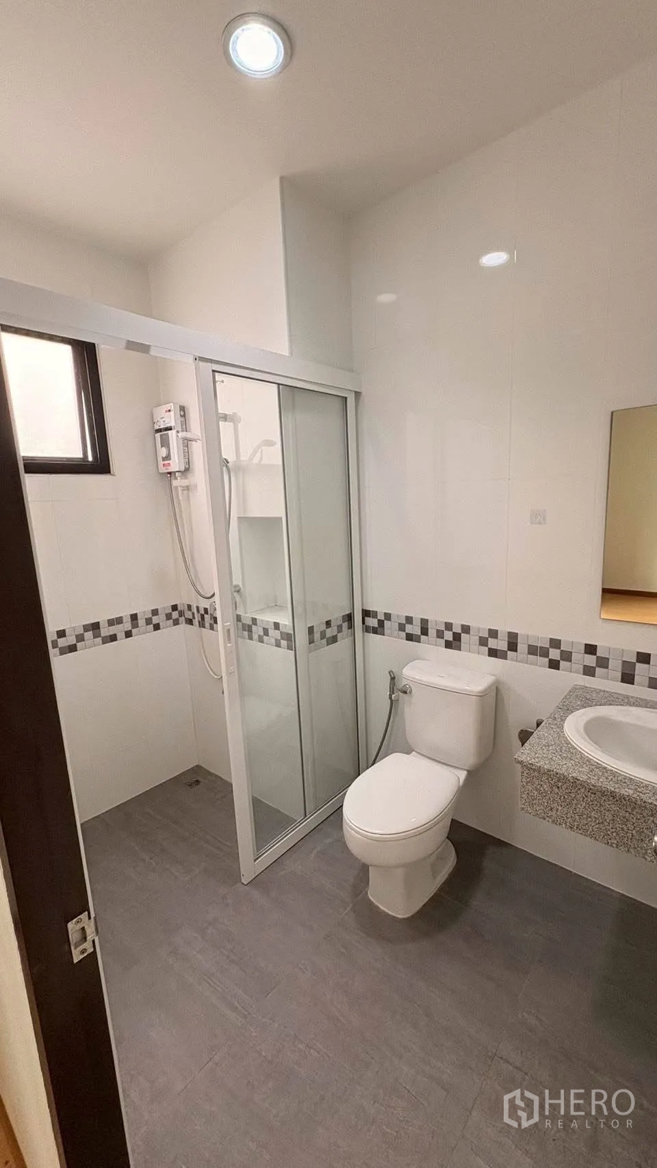 联排别墅 for rent in Phra Khanong, Bangkok - 浴室带玻璃淋浴房、热水器、台盆与马桶。