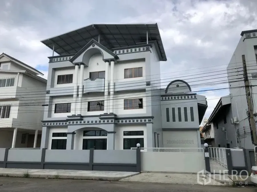 工厂 出租在Pak Kret, Nonthaburi - 三层厂房办公楼外观，带围墙与大屋檐遮棚