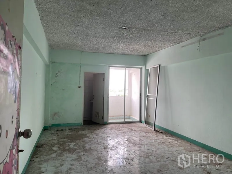 Apartment for sale in Mueang Samut Prakan, Samut Prakan - Unfurnished apartment room with sliding balcony door and connected bathroom.