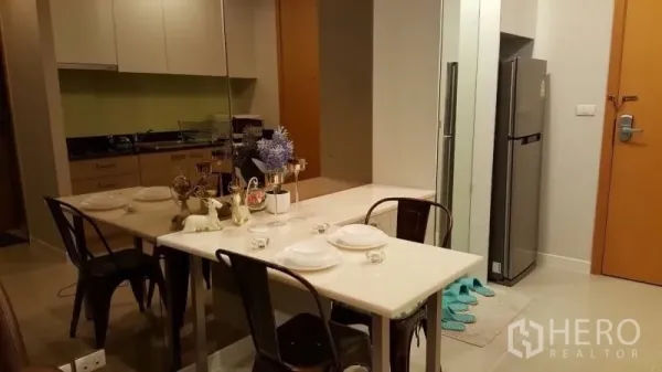 คอนโด ให้เช่าหรือขายในRatchathewi, Bangkok - ครัวกะทัดรัดและพื้นที่รับประทานอาหาร โต๊ะหินอ่อน 4 ที่นั่ง ผนังกระจกเงา และตู้เย็นสแตนเลส