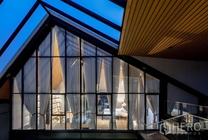 สำนักงานที่บ้าน ขายในKhlong Toei, Bangkok - โถงหลังคาทรงจั่วกระจก เห็นห้องนอนพร้อมผ้าม่านในยามค่ำคืน