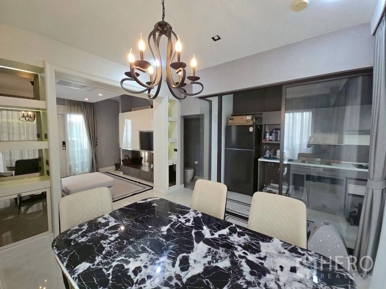 ทาวน์เฮาส์ ให้เช่าหรือขายในLat Phrao, Bangkok - ห้องทานอาหารโต๊ะหินอ่อนสีดำ โคมระย้า และครัวกั้นกระจก