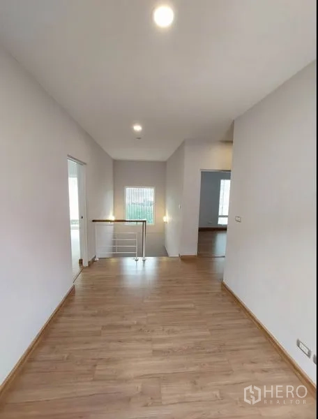 บ้าน ขายในBang Yai, Nonthaburi - โถงชั้นบนพร้อมพื้นไม้และราวบันไดสีขาว