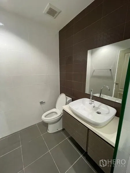 Townhouse for rent in Bang Kapi, Bangkok - Second bathroom featuring vessel sink, large mirror and gray tiled floor.