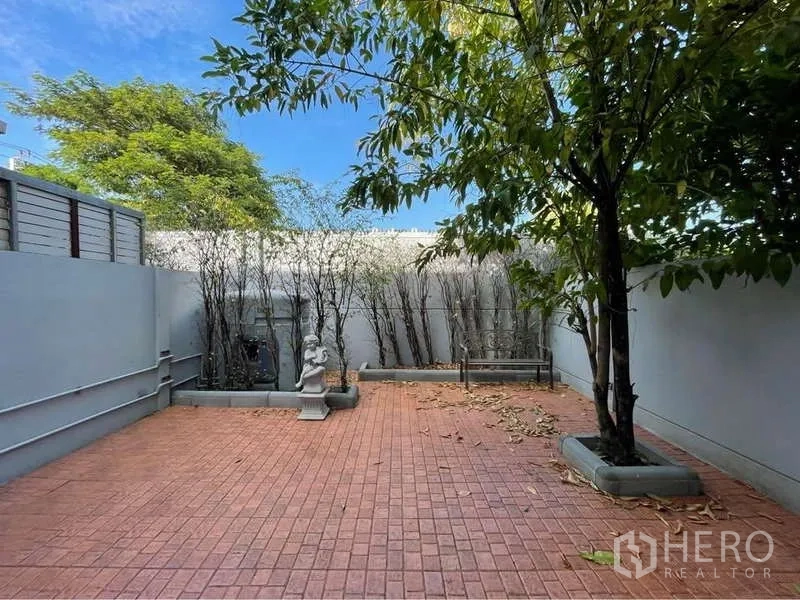 Detached House for rent in Prawet, Bangkok - Private back patio with brick pavers, shade trees and boundary wall.