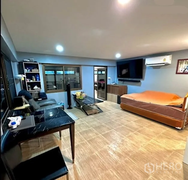 Detached House for sale in Bang Bua Thong, Nonthaburi - Family room with sofa bed, wall-mounted TV and built-in storage units.