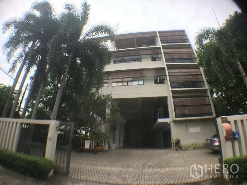 办公空间 出租在Phra Khanong, Bangkok - 曼谷Phra Khanong低层办公楼外观，带大门与棕榈树。