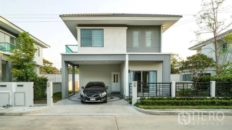 บ้าน ให้เช่าหรือขายในLat Krabang, Bangkok - บ้านเดี่ยวสองชั้นสมัยใหม่ พร้อมที่จอดรถในร่ม หน้าบ้านมีรั้วและทางรถยนต์ในโครงการเงียบสงบ