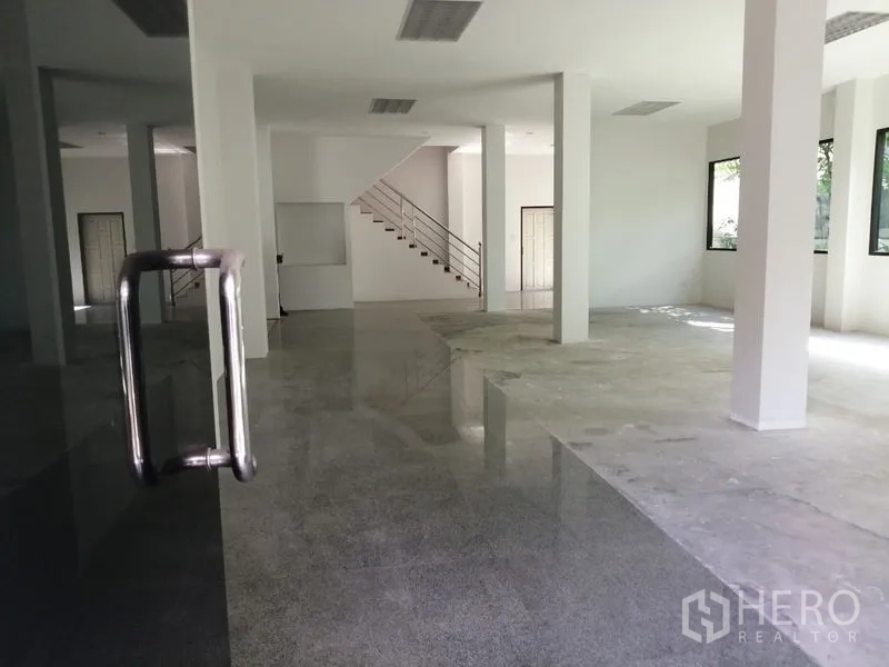 Home Office for rent in Watthana, Bangkok - Spacious ground floor open-plan space with columns, staircase and polished floors.